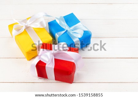 White wooden table with wrapped gifts top view