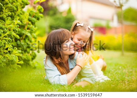 Young mother and daughter having fun together outdoors