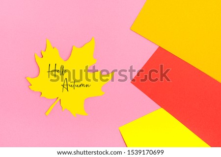 autumn leaf cut out of yellow paper on abstract geometric background of colored paper - yellow, red, orange colors Hello autumn concept Top view Flat lay Mock up