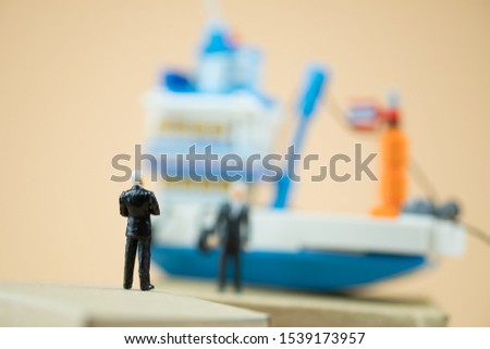 Miniature people : businessman negotiate global business logistics import export with ship background