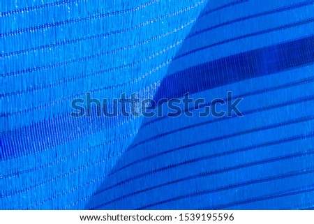 Closeup blue shade net fabric pattern (Slant) for sunlight protection in construction site. 