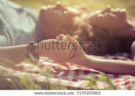 Take my hand and let’s make this last forever. Couple lying on grass.