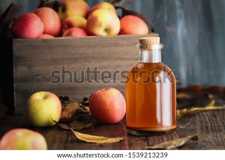 Apple cider vinegar with the mother, yeast and healthy bacteria, surrounded by fresh apples. This has been used to naturally treat things such as diabetes and high cholesterol.