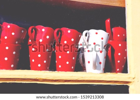 vintage red and white dot cups stand on a wooden shelf, home life theme
