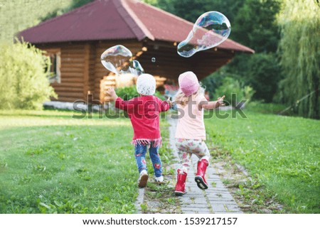 happy  girls playing with soap bubbles outdoor. 