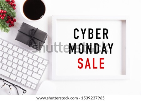 Cyber Monday Sale text on white picture frame with keyboard mouse coffee cup, gift box and Christmas tree decoration, red berries on white background. Shopping concept and Cyber Monday composition.