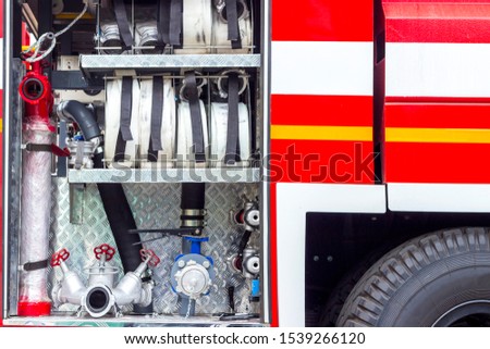 Fire engine, side view, neatly folded equipment inside the fire engine.