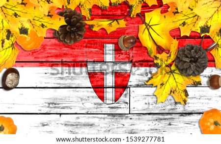 Vienna flag on autumn wooden background with leaves and good place for your text