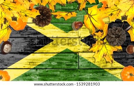 Jamaica flag on autumn wooden background with leaves and good place for your text