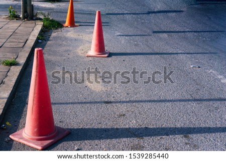 3 red traffic cones on the road