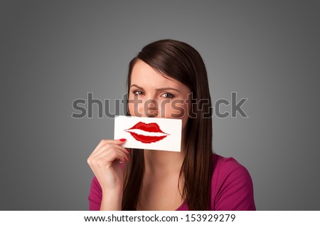 Happy pretty woman holding card with kiss lipstick mark on gradient background