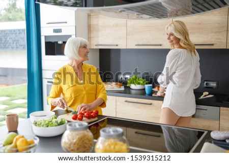 Happy mature women standing together in the kitchen stock photo
