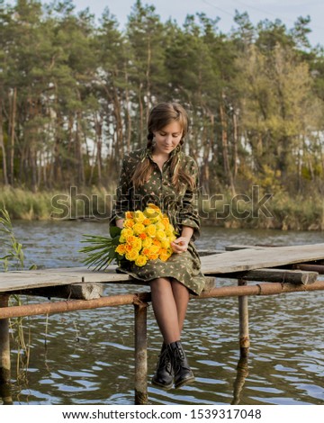 Beautiful girl with a bouquet of yellow roses. Effective woman near the river. Pretty Woman. Teen girl with yellow roses. Girl on the old bridge.