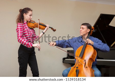 Musicians of the symphony orchestra. Young violinist and cellist in concert costumes. Portrait.