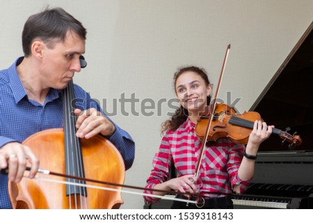 Musicians of the symphony orchestra. Young violinist and cellist in concert costumes. Portrait.