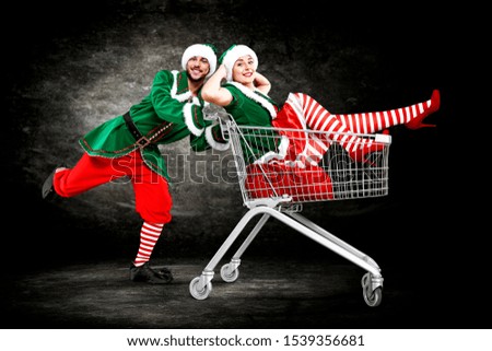 Two lovers on black background and christmas shopping time. 