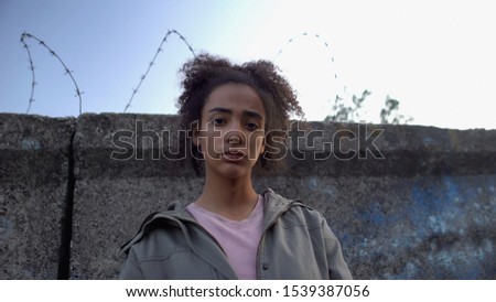 Teen girl looking at camera, dreaming to escape prison, juvenile delinquency Royalty-Free Stock Photo #1539387056