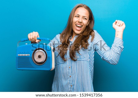 young woman with a vintage radio against blue background