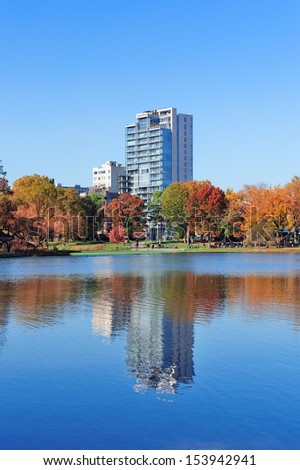 Autumn in Central Park north end in New York City Manhattan with buildings, lake and colorful foliage with clear blue sky.