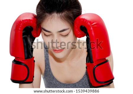 Asian Woman Wearing Red Boxing Gloves.The girl put her hands on her ears.Lady are tired.She has pain in the neck area.Women are headache severely.Lady are stressed.
