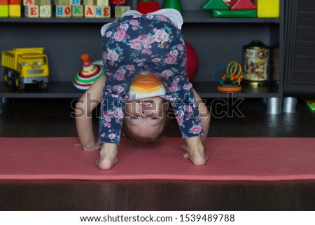 Little girl bending down making physical training