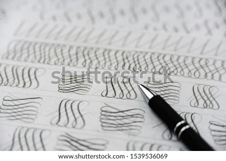 Handwriting calligraphy sheets. Design elements and pen close up. Handwritig day concept