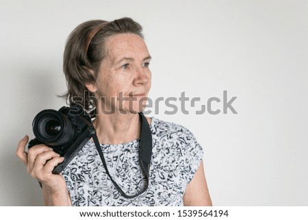 senior woman photographer hold camera look decide take a picture
