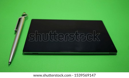 Tablet Phone with Stylus isolated in the Green Background                               