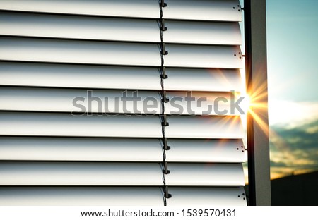 Closed external metal jalousie with reflections of sunray's Royalty-Free Stock Photo #1539570431