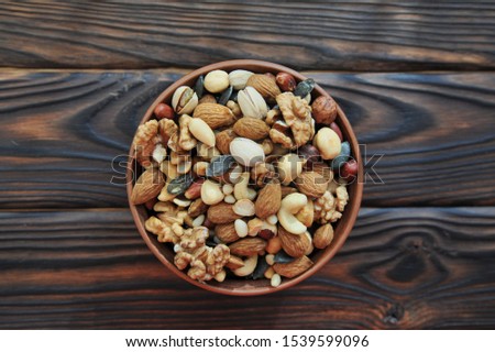 clay grater with nuts on a wooden surface. view from above Royalty-Free Stock Photo #1539599096