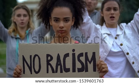 Afroamerican girl holding No racism sign, activists chanting Human rights slogan Royalty-Free Stock Photo #1539601763