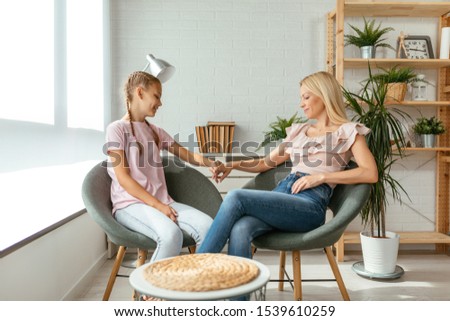 Young mother and her daughter at home spending time together at home