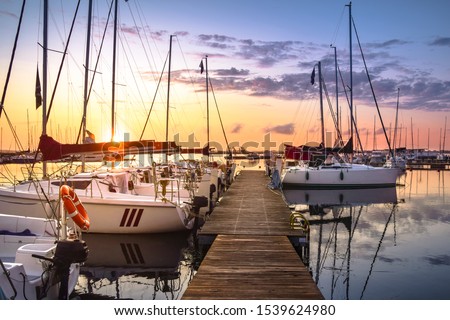 Boats moored in the marina at Lake Niegocin during sunrise. Wilkasy, Masuria, Poland. Royalty-Free Stock Photo #1539624980