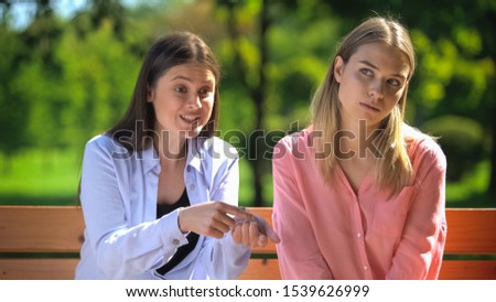 Tired female listening to annoying friend sitting outdoors, envy, selfishness Royalty-Free Stock Photo #1539626999