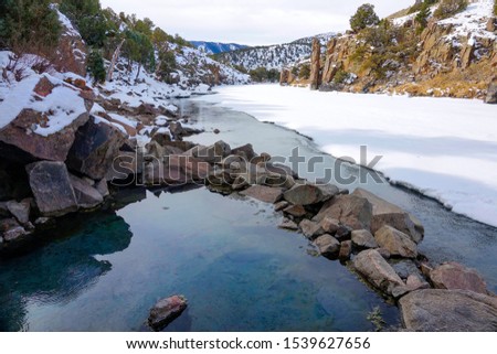 CLOSE UP: Picturesque view of an emerald colored natural hot bath overlooking the picturesque snowy landscape of Colorado. Gorgeous wintry nature surrounds the Radium Hot Springs. Beautiful scenery Royalty-Free Stock Photo #1539627656