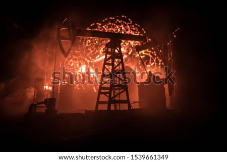 Oil pump and oil refining factory at night with fog and backlight. Energy industrial concept. Selective focus. Artwork decoration.