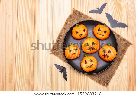 Funny Halloween Sushi Pumpkins Jack o Lantern, Sushi Monsters. Temari sushi, sushi balls. Healthy food for kids. Bats, sackcloth, wooden boards background, copy space, top view