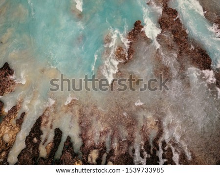 Bird's eye view of turquoise water and foam in Nusa Penida, Indonesia. Abstract background, drone photography