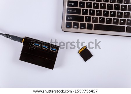 Workplace photographer copying photos from memory SD cards to laptop computer