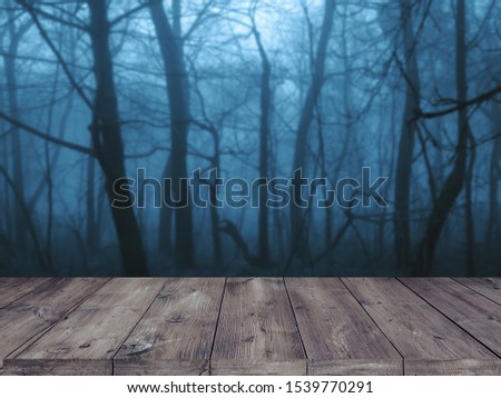 Old wood table and silhouette dead tree at night for Halloween 