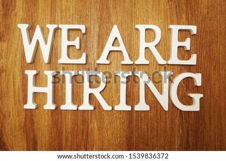 We are Hiring word alphabet letters on wooden background