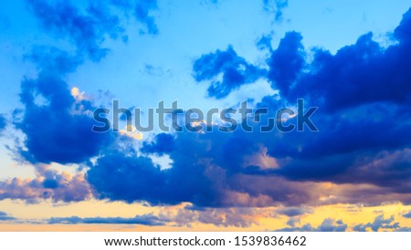 Bright cumulus clouds against the blue sky. Sunset sky Natural background.