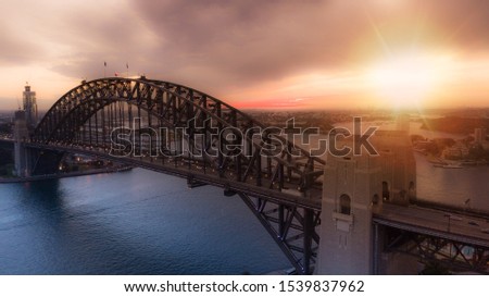 Aerial view of Sydney Harbour Bridge during golden hour sunset.
