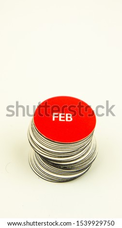 Red magnet clip with text FEB (FEBRUARY) on white background. Name of month concept for calendar.