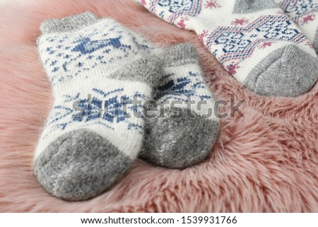 Knitted socks on pink faux fur, closeup