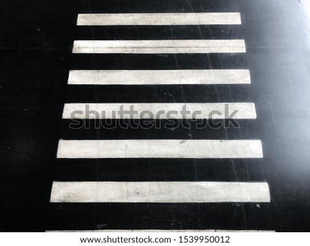 Zebra cross on the black floor. Top view close up details.
