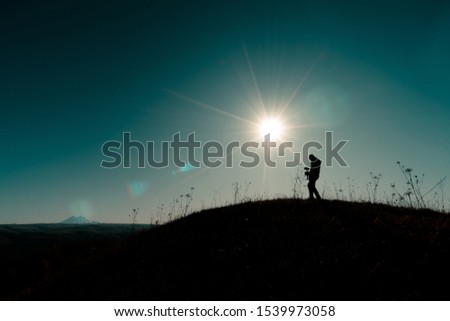 silhouette of a guy with a camera in the mountains