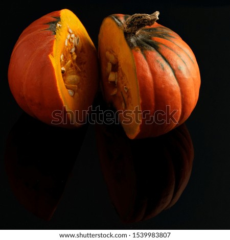 
slices in half pumpkin on a dark mirror