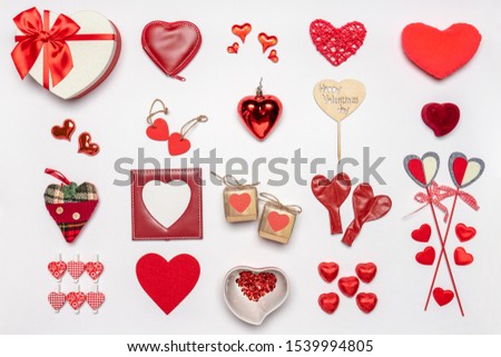 Various hearts and stylish accessories in heart shape, gifts and sweets in red color on white background. Empty photoframe, mock up. Greeting card for Valentine's day, love and romance concept