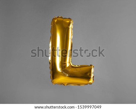 Golden letter L balloon on grey background